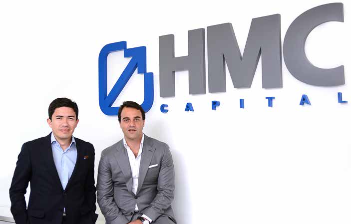 Ricardo Morales, left, and Felipe Held, right, seated beneath HMC Capital lettering
