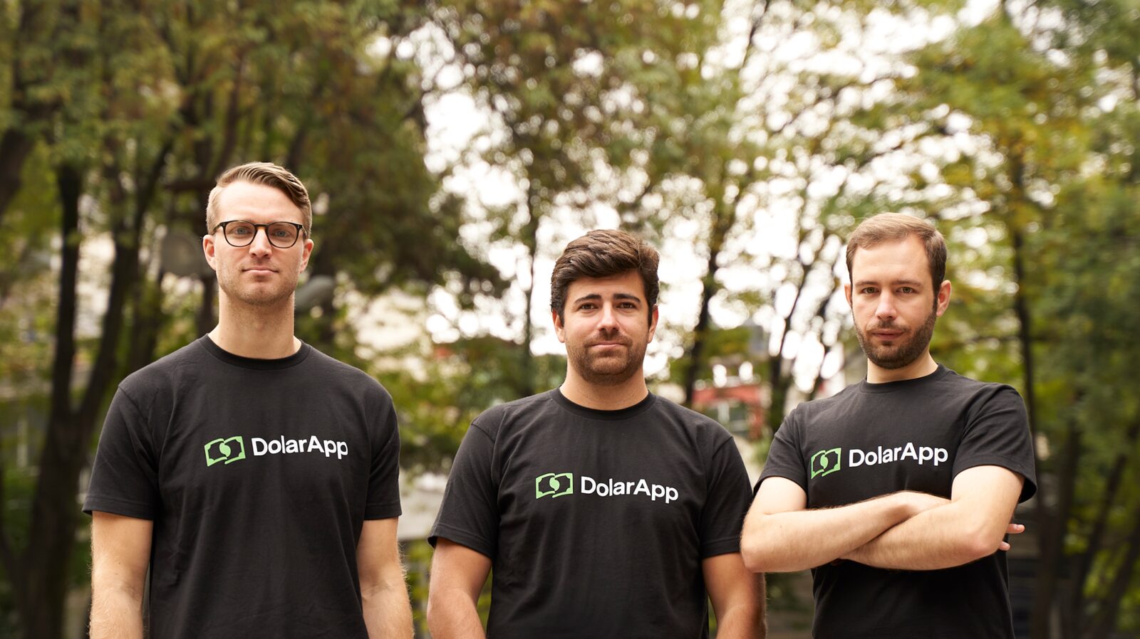 DolarApp's three co-founders outdoors in black company T-shirts; Fernando Terrés stands on the right