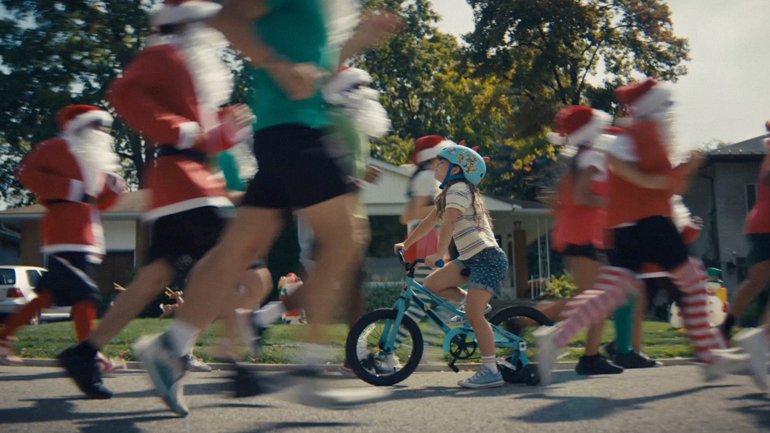 A child on a bicycle moves through a neighborhood Christmas parade in FIG's Merry Birthday campaign for Publix