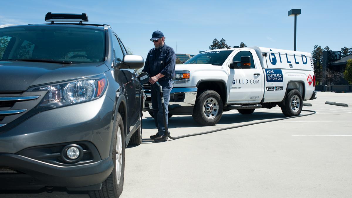 A Filld driver refuels a parked SUV from a branded mobile fueling truck