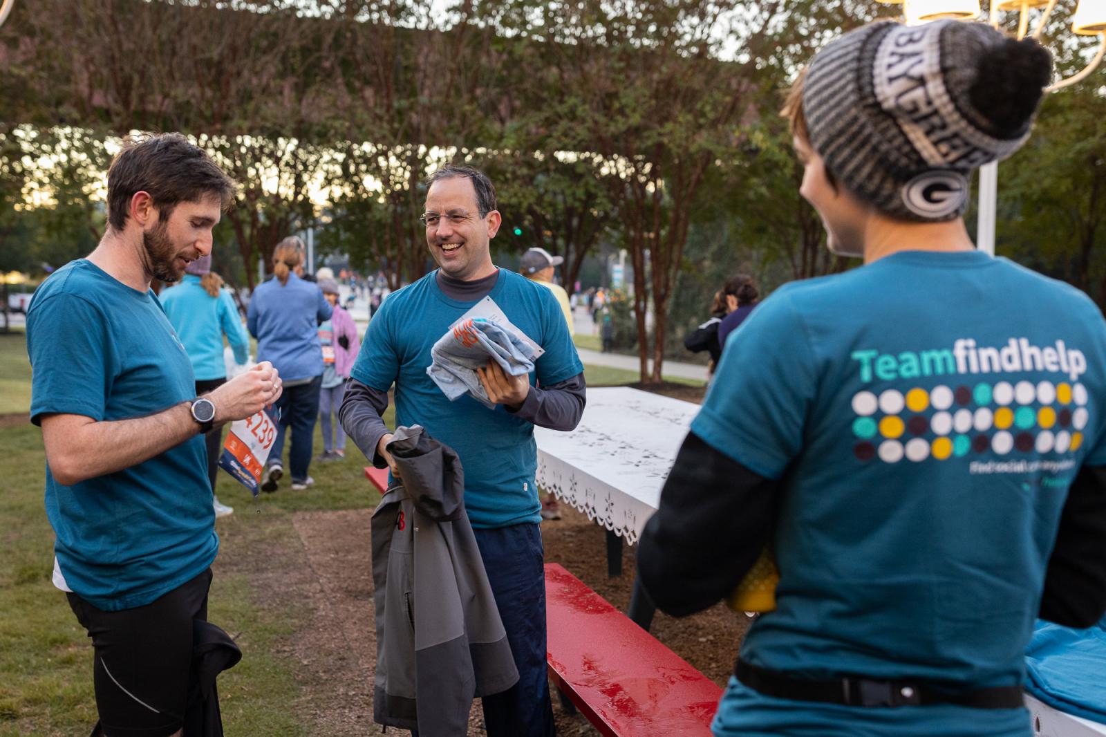 Findhelp founder Erine Gray, center, smiling with people in Team Findhelp shirts at an outdoor event