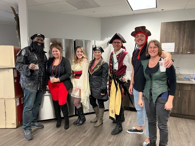 Fintech employees celebrating Gasparilla in pirate costumes at the Tampa office