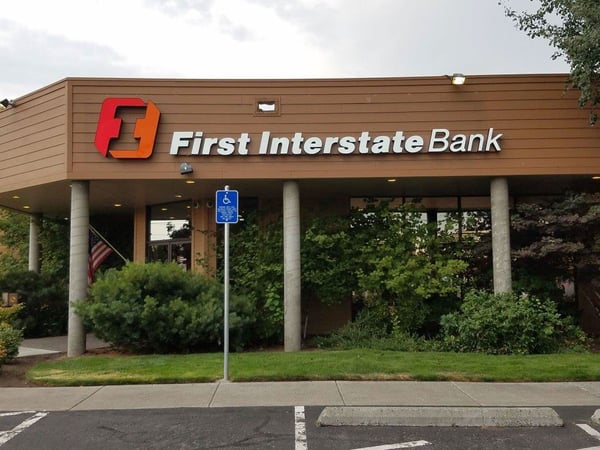 First Interstate Bank’s Bend South branch, with its orange sign above a planted entrance