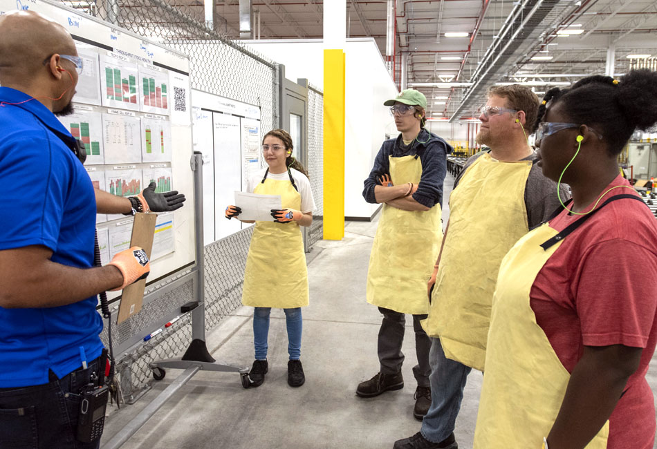 First Solar associates speaking together inside a manufacturing facility