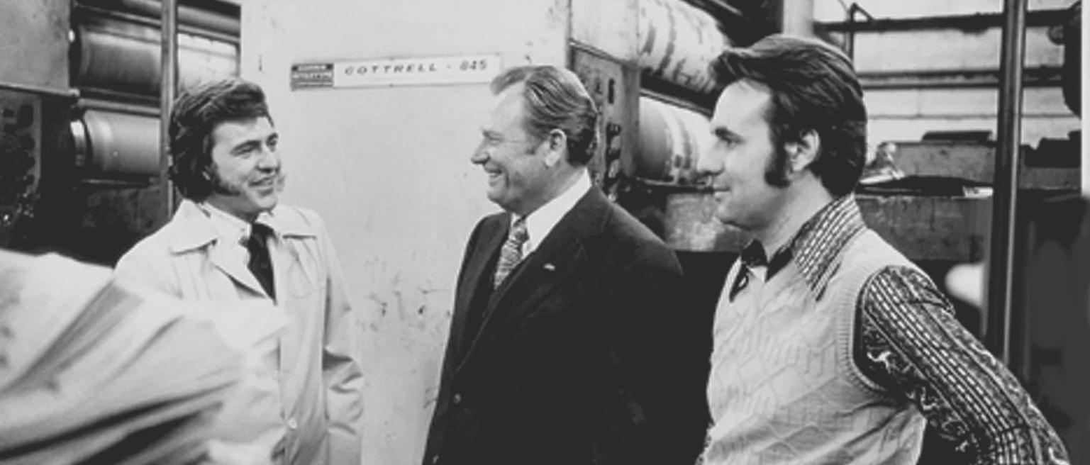 Historical photograph supplied by Fisher showing three men beside industrial equipment