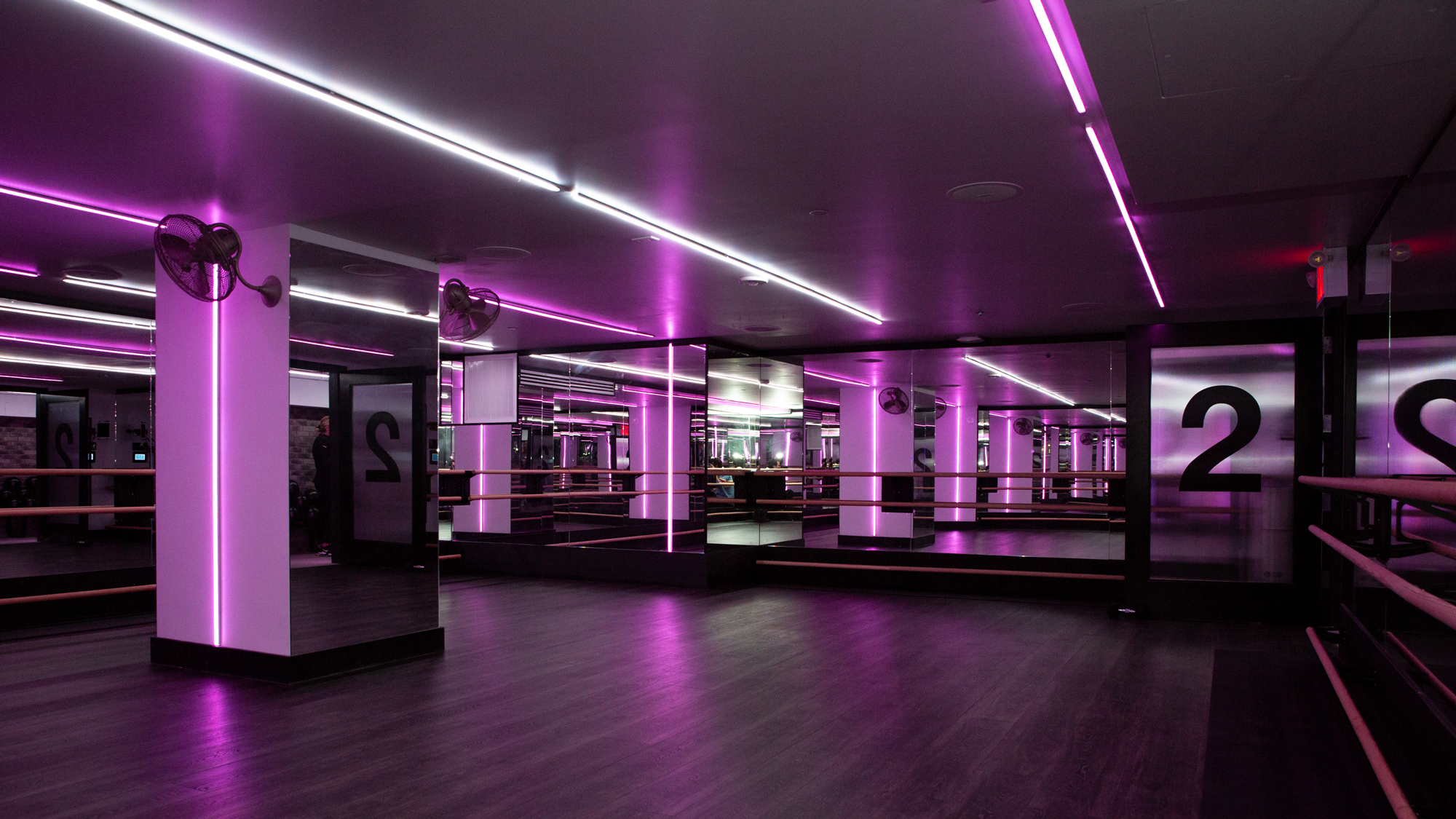 Fithouse studio with mirrored walls, ballet barres and purple and white strip lighting