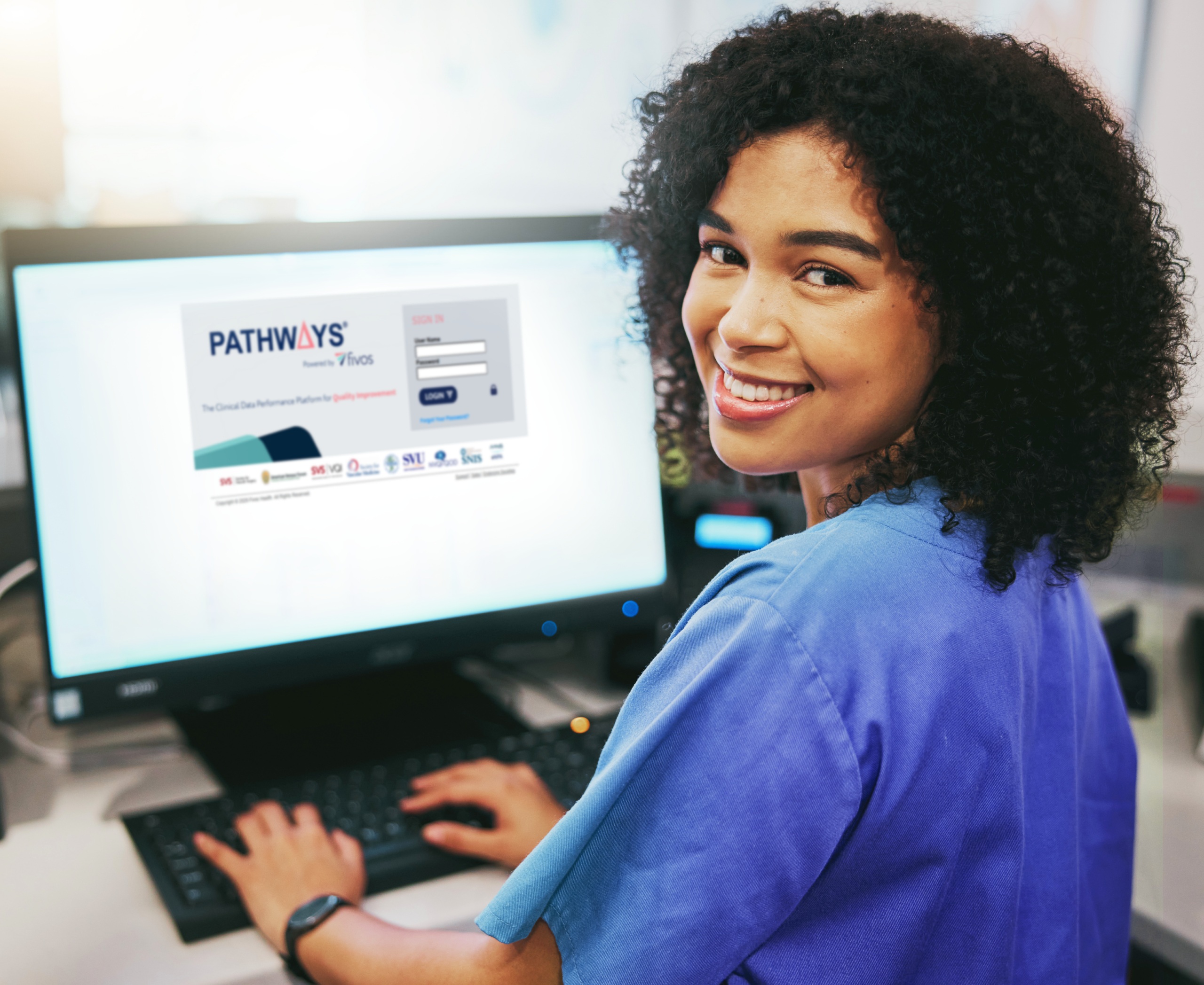 Fivos promotional photograph showing the PATHWAYS sign-in screen on a desktop monitor