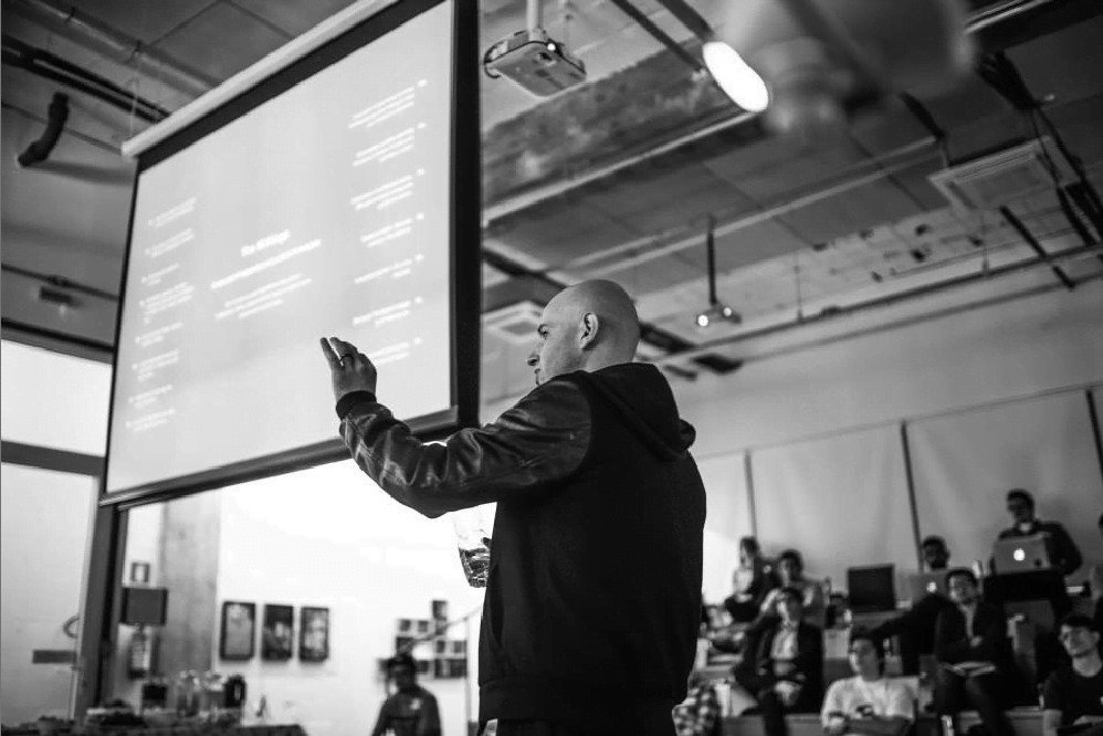 FLAGCX co-founder Roberto Martini speaking to a group in a studio-like workspace