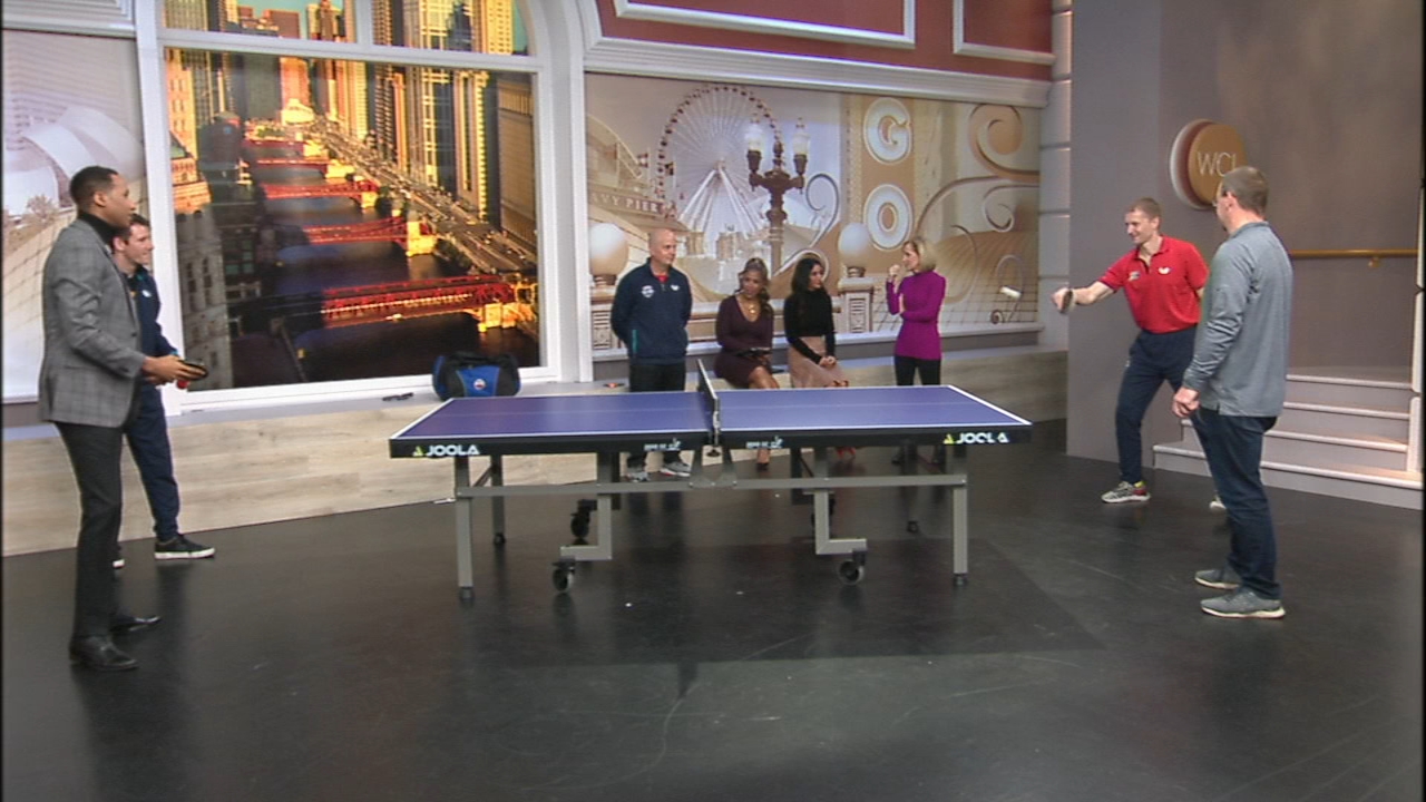 Flint Lane and professional players join ABC7 Chicago presenters beside a table tennis table