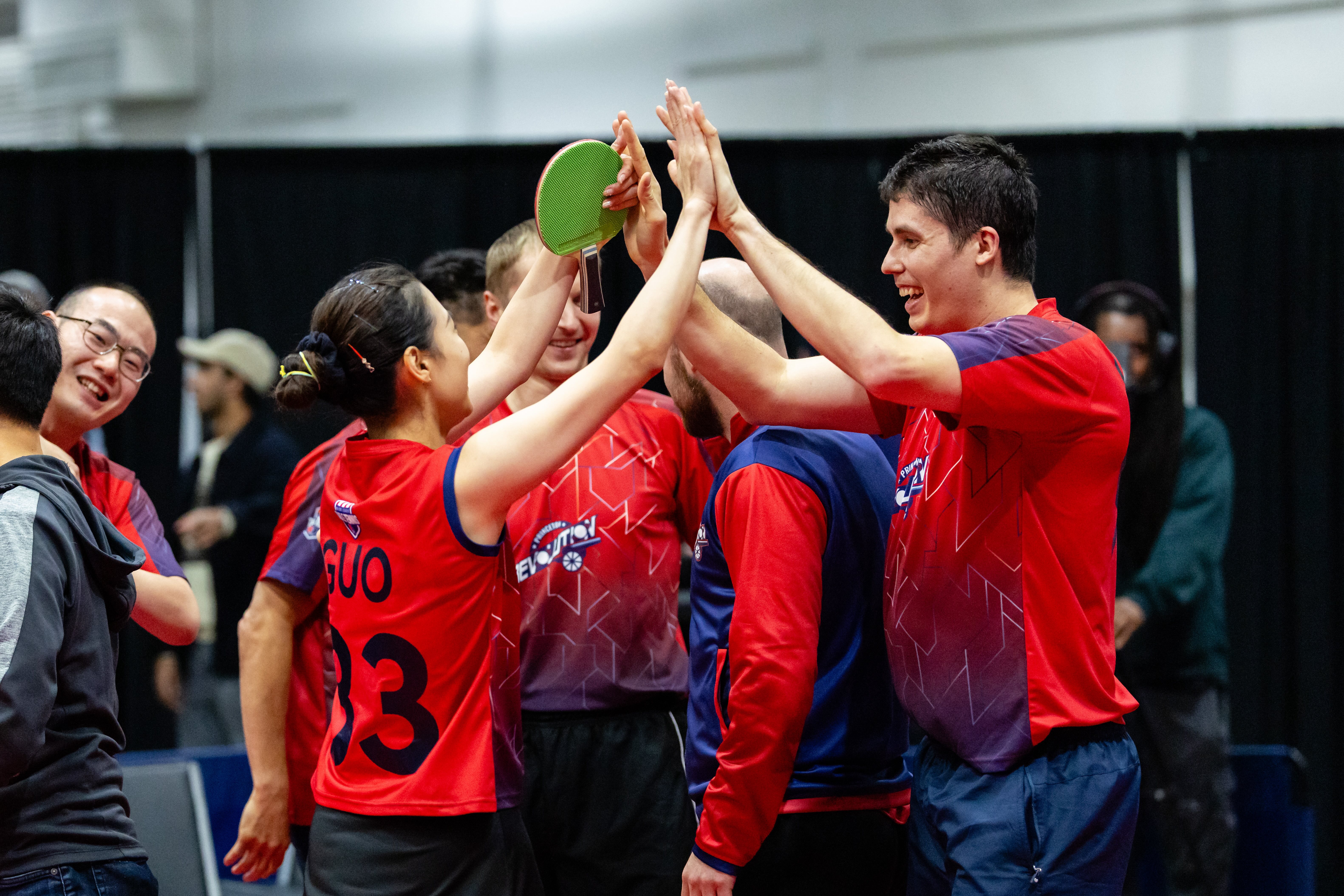 Princeton Revolution players celebrating together with raised hands and a paddle