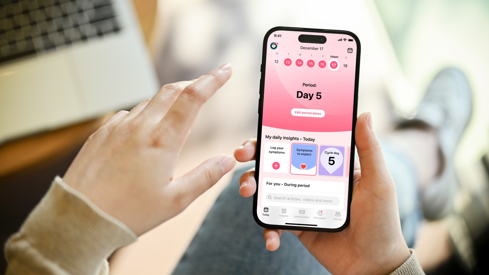 A person holds a phone showing Flo’s period-tracking screen.