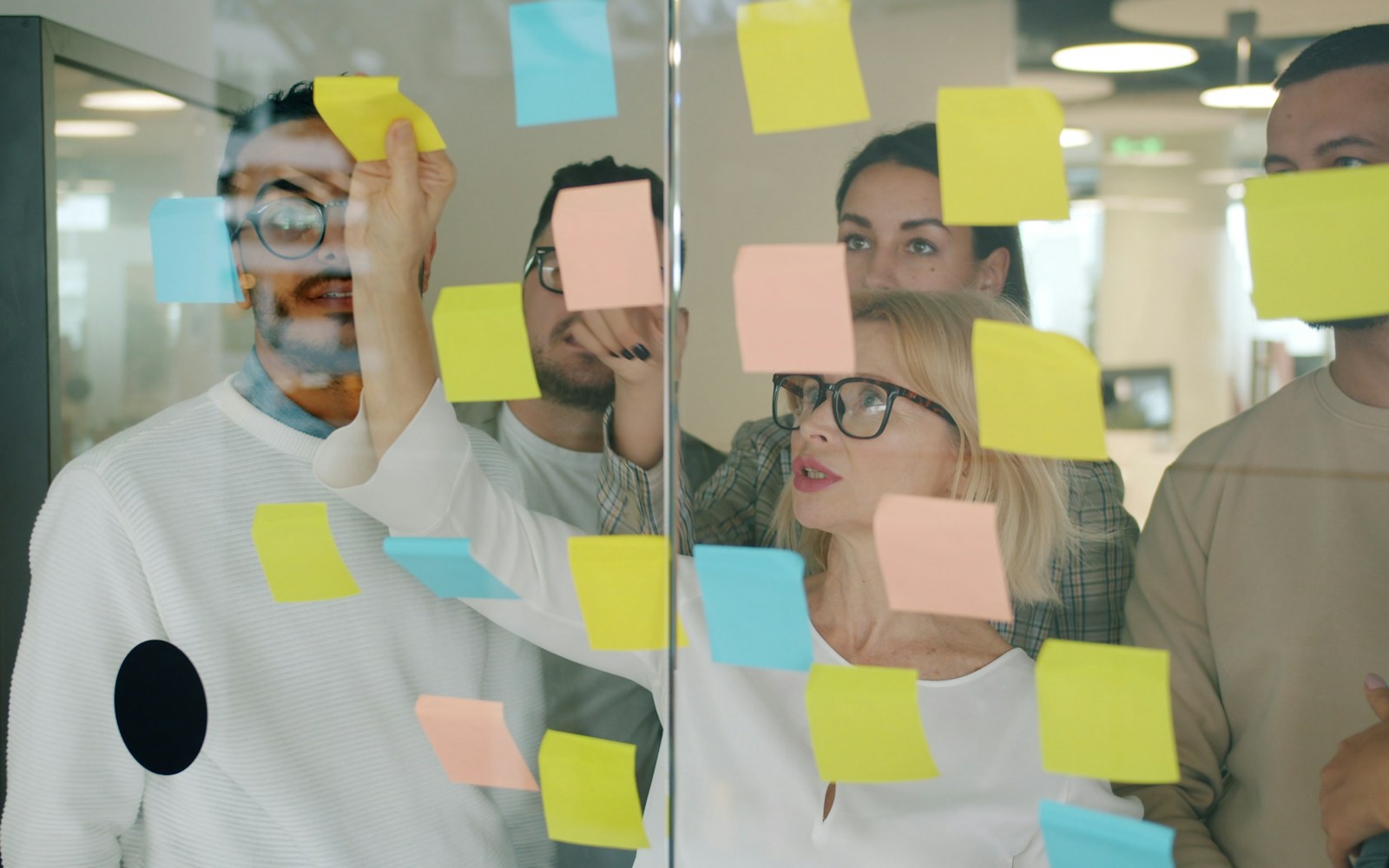 Team planning work with notes on a glass wall