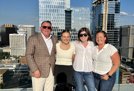 Four Flock employees together on a rooftop with city buildings behind them