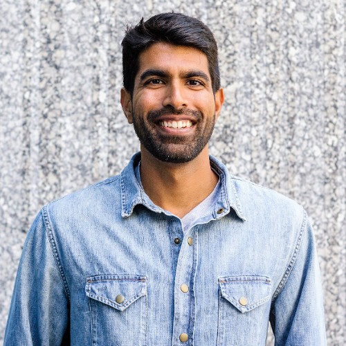 Flockjay founder Shaan Hathiramani smiling in a denim shirt