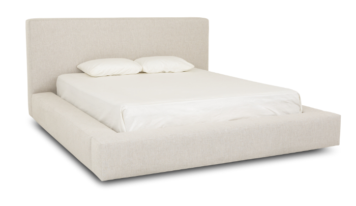 Flores Design cream upholstered bed with a broad headboard and low platform