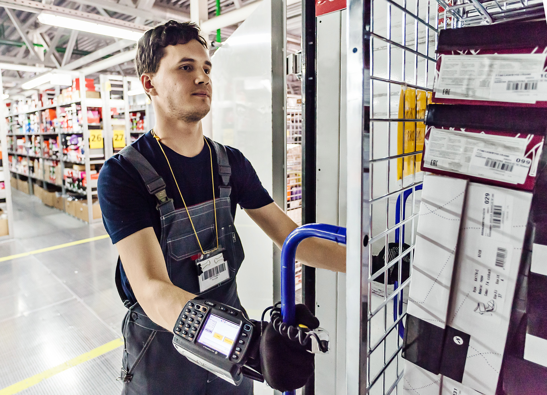 A Lamoda warehouse employee moves stock beside shelves of shoe boxes