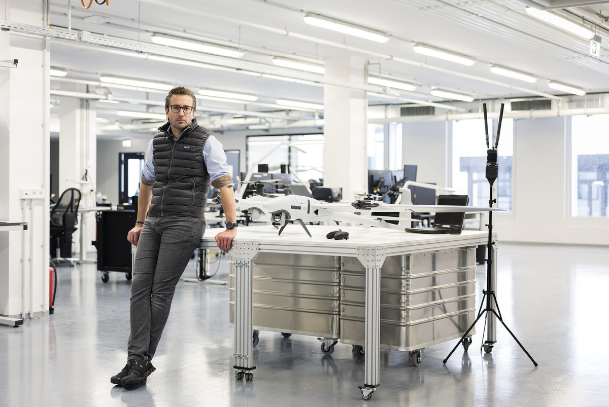 Florian Seibel beside a workbench holding white fixed-wing drones inside a Quantum Systems workshop.