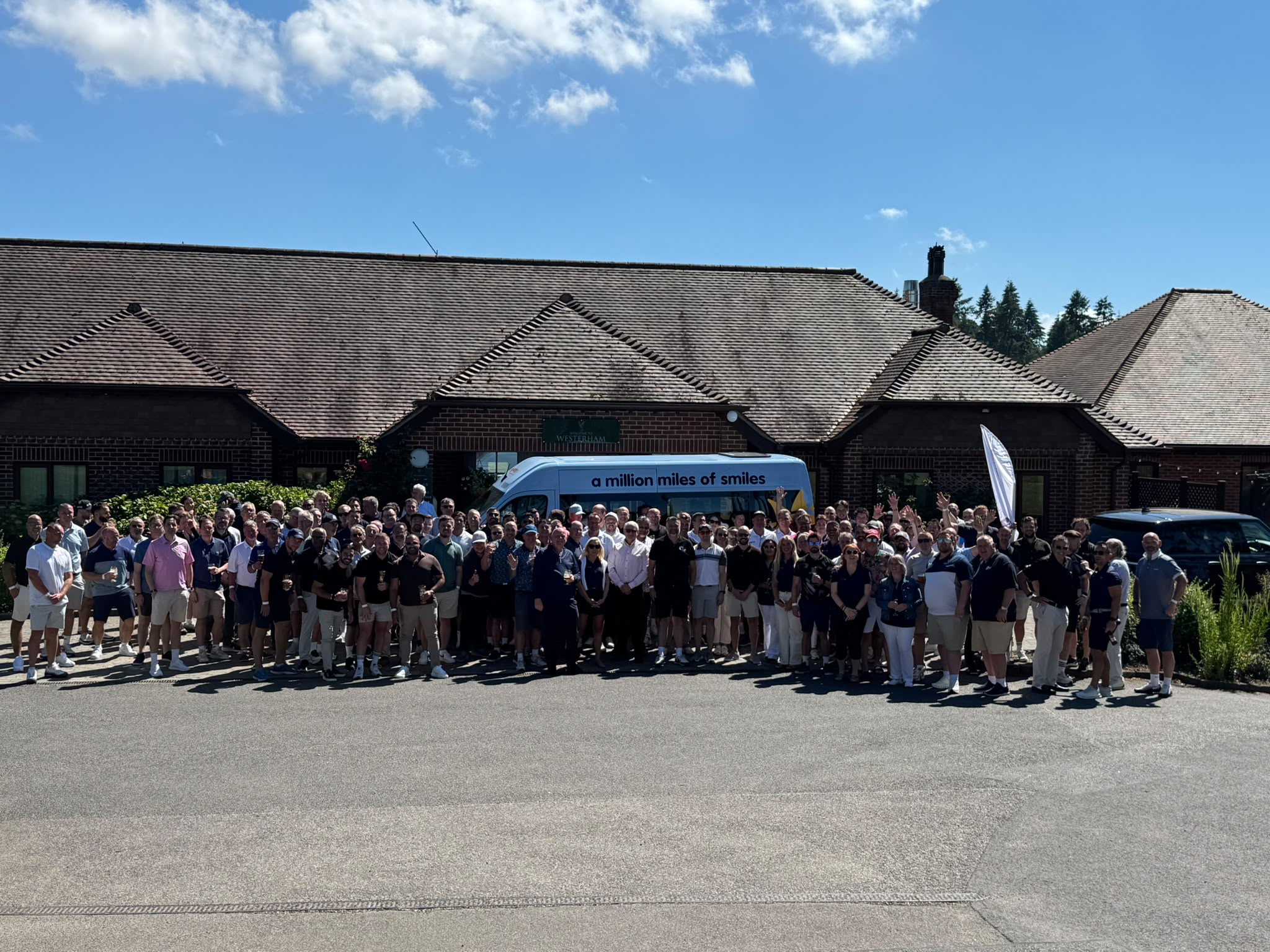 Participants gathered outside Westerham Golf Club with the Sunshine Coach at FLR Spectron’s 2026 charity golf event