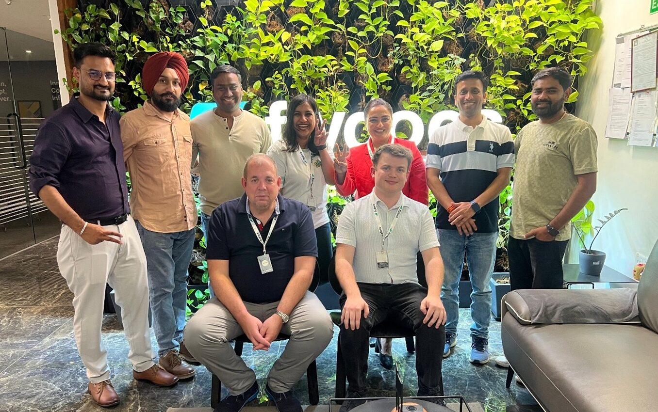 flydocs Lifecycle Asset Management team gathered in front of an indoor plant wall