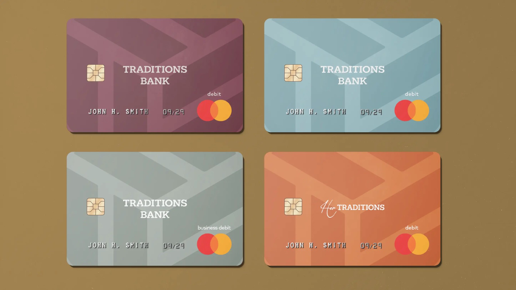 Four Traditions Bank debit cards designed in muted blue, coral and burgundy tones