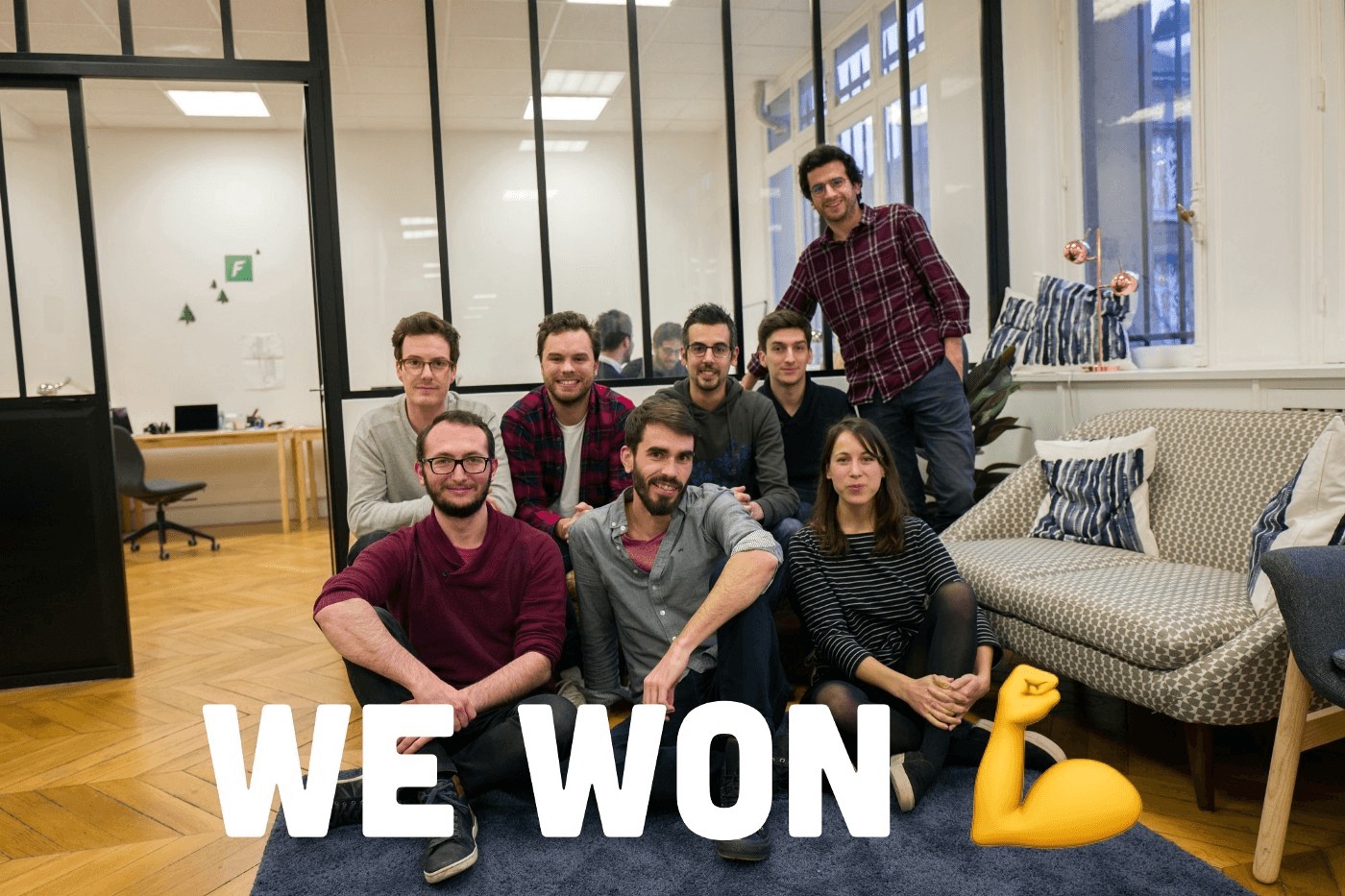 The early Forest Admin team gathered in their office beneath a We Won caption