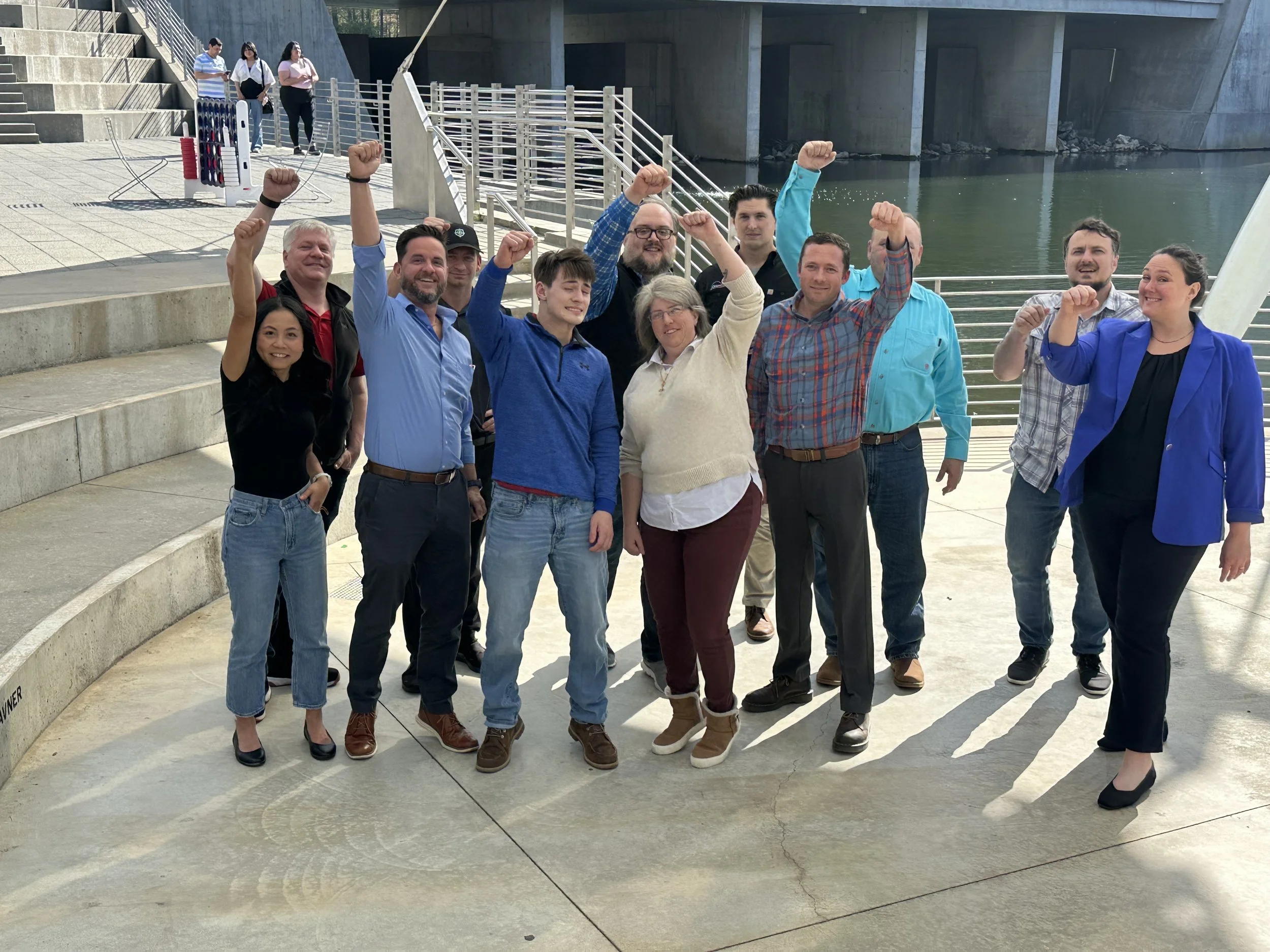 Phoenix cohort group pictured outdoors with raised fists
