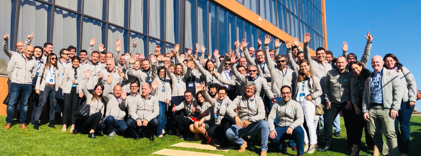 ASP team gathered outdoors in front of a company building