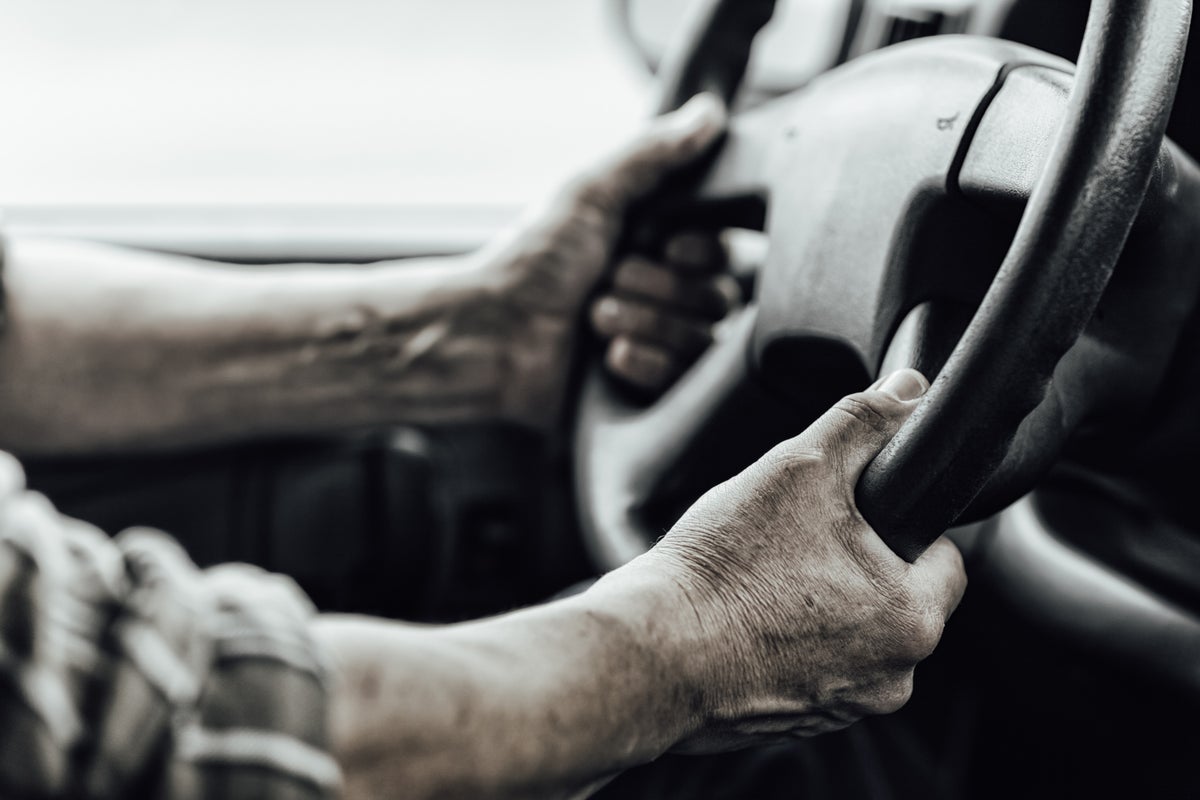 Close view of a driver’s hands on a truck steering wheel