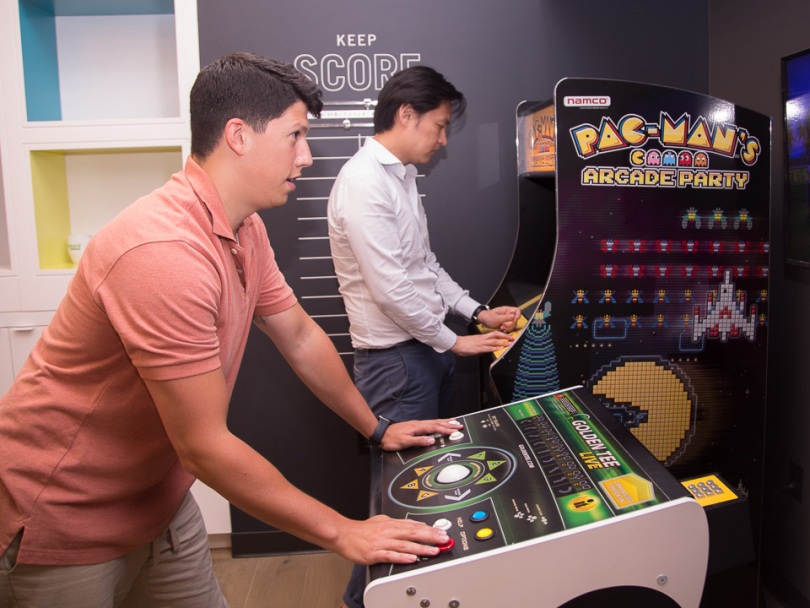 Two Forward Financing employees play arcade games in the office in 2019