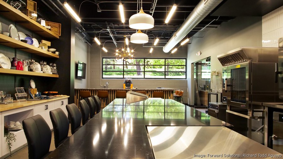 Curate’s Kansas City culinary center with a long demonstration counter, seating and commercial kitchen equipment