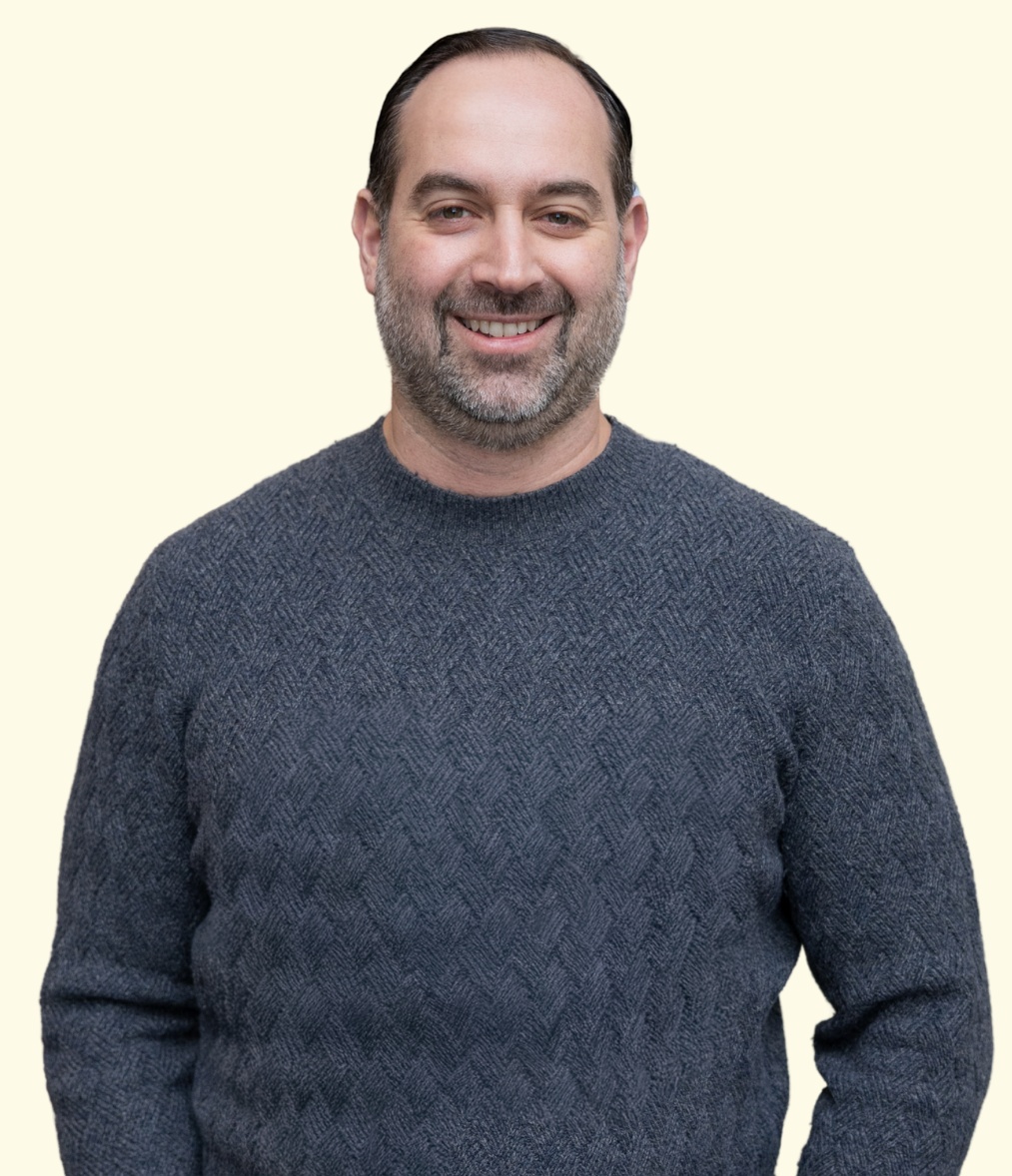 Founders Journey host Jimmy Douloumbakas smiling in a dark sweater