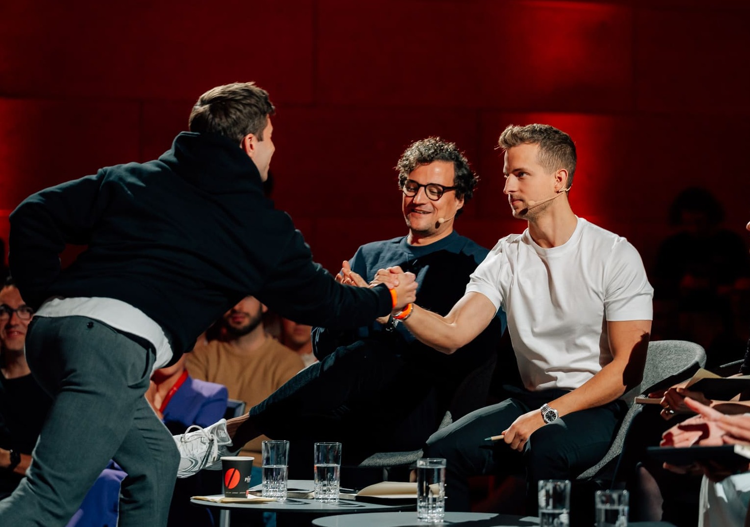 A participant greeting seated jury members at the Munich Founders League event
