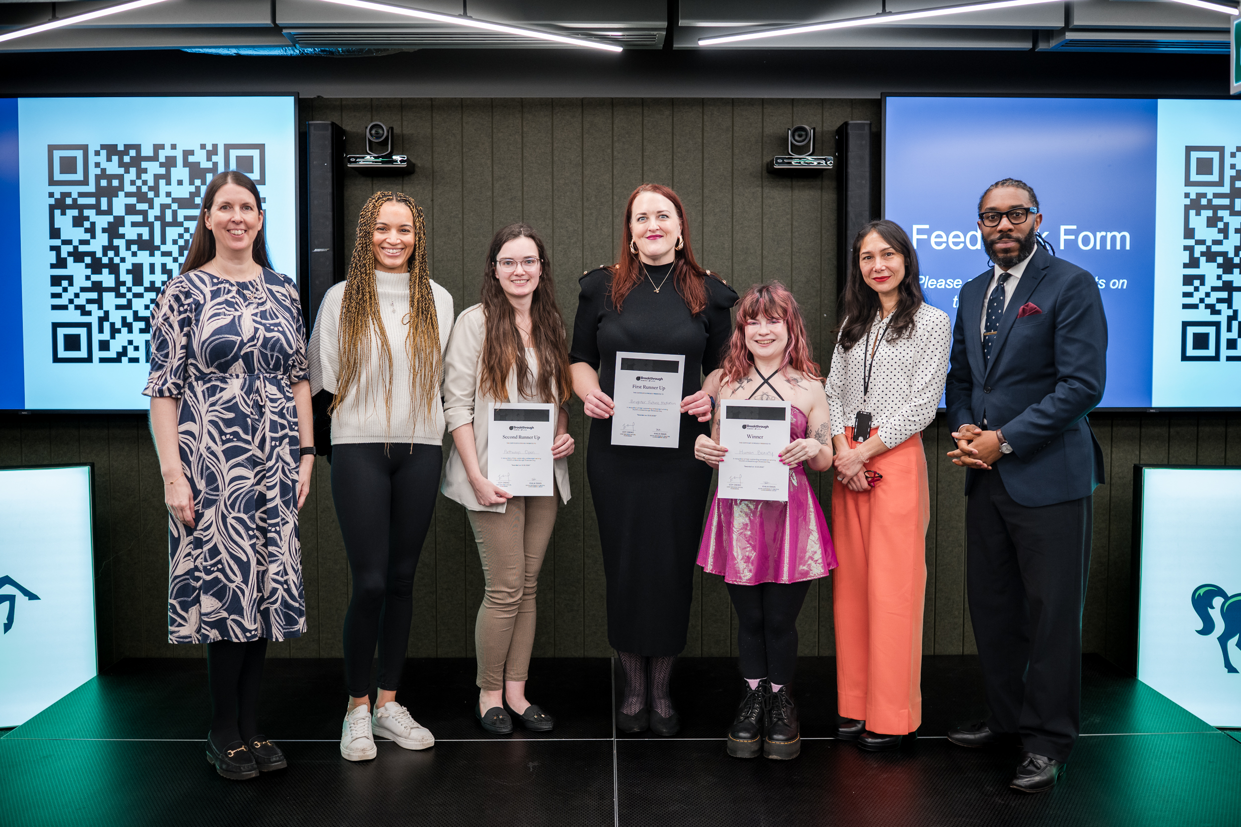 Breakthrough grant winners hold award certificates alongside programme representatives at Demo Day.