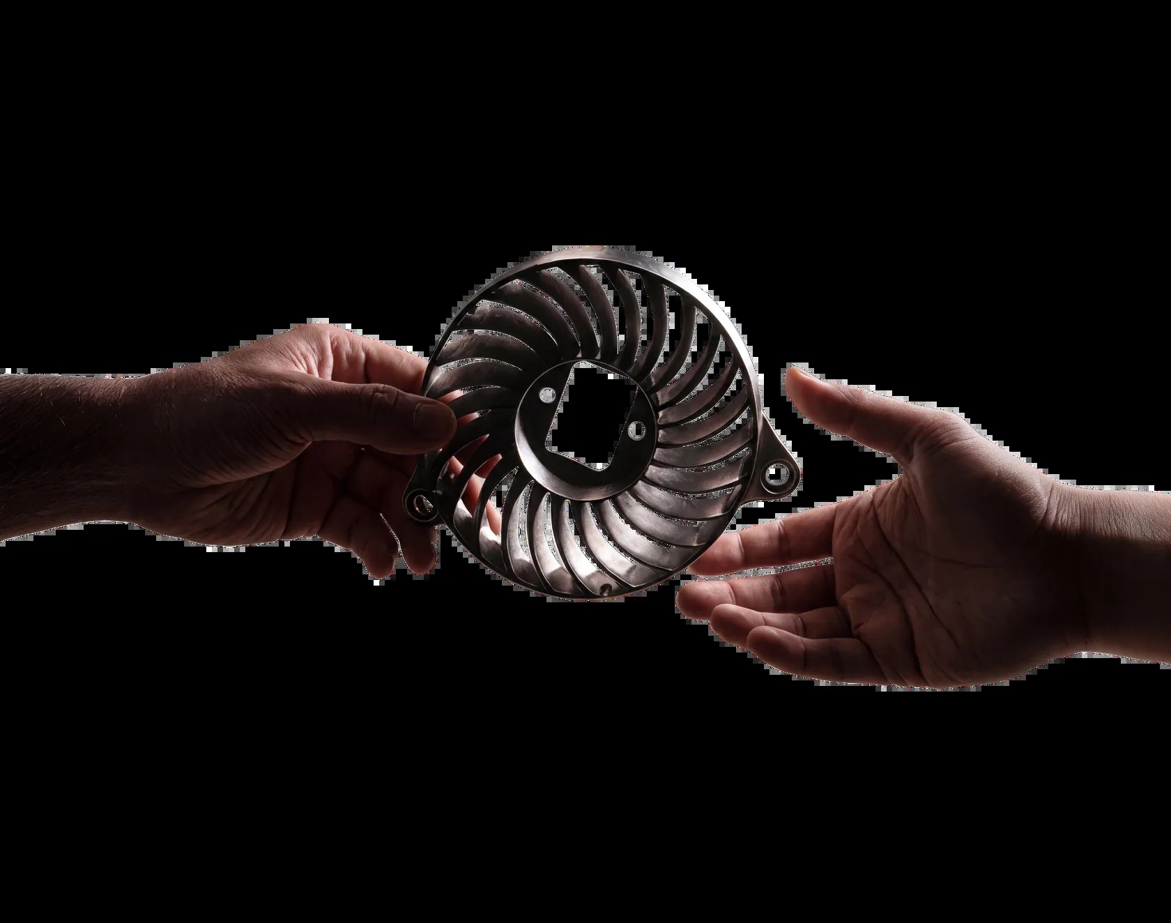 A detailed cast metal component held between two hands