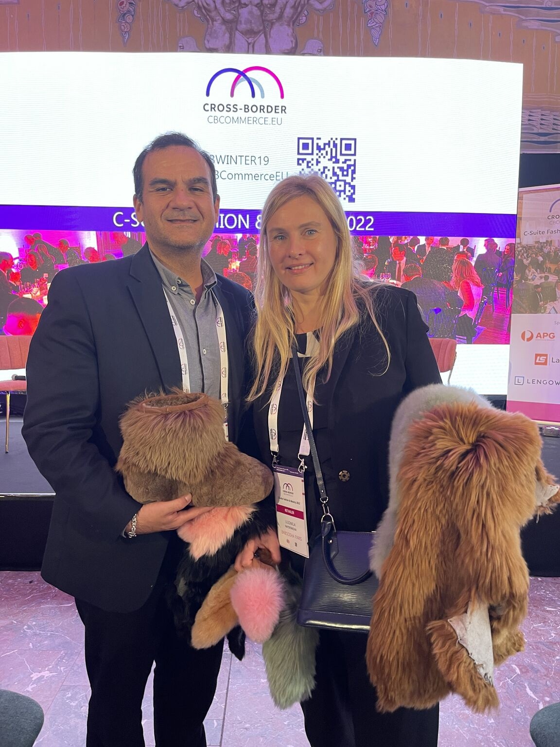 Frank Amoros and Liudmila Naydenkova holding Baboosha footwear at the 2022 Cross-Border Commerce Europe fashion and beauty event