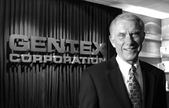 Fred Bauer standing beside the Gentex Corporation sign in a photograph from the 2007 annual report