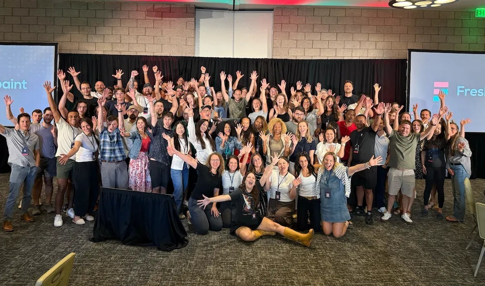 Freshpaint team gathered for a group photograph, waving at the camera