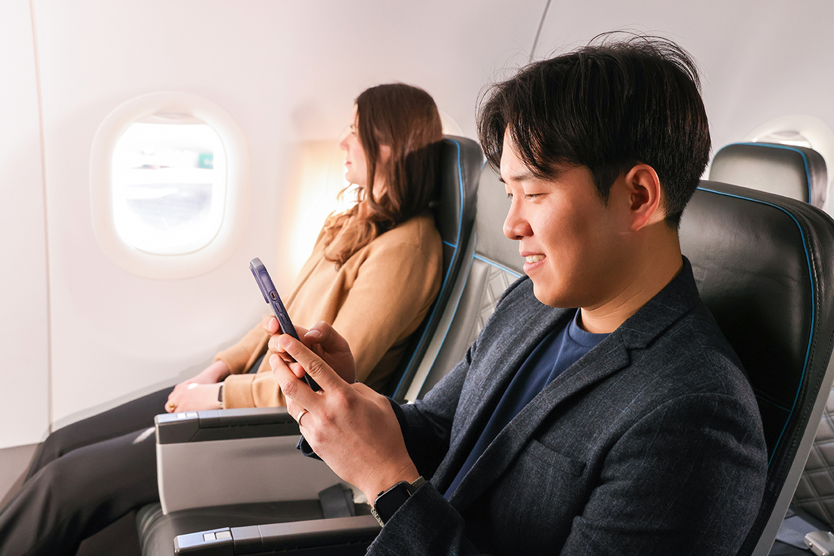 Frontier promotional photograph showing two UpFront Plus passengers separated by an empty middle seat