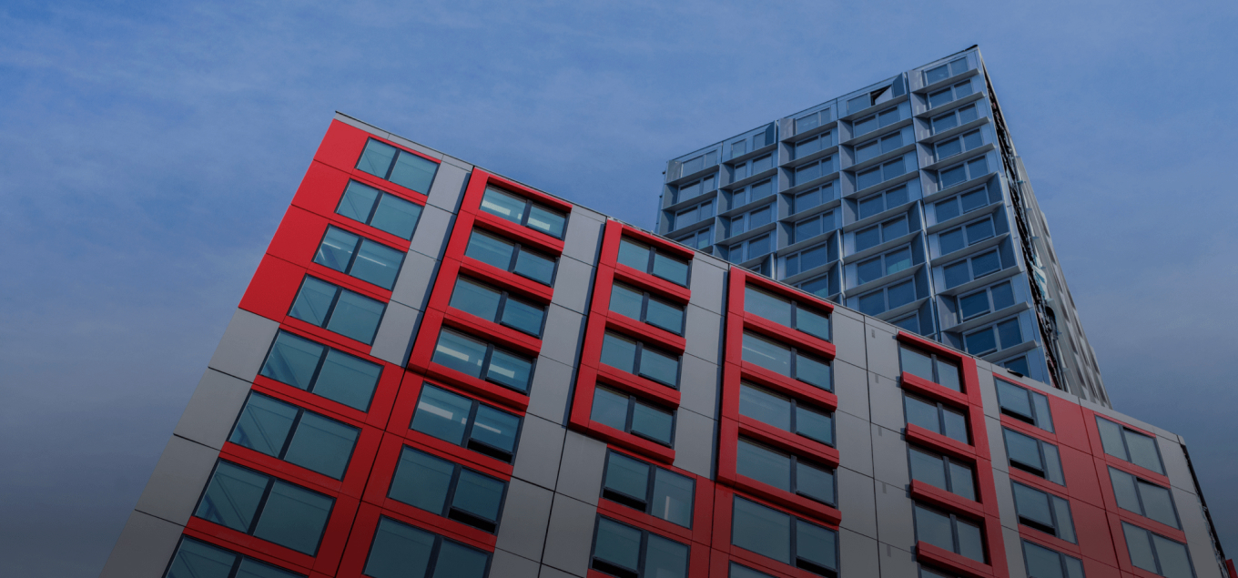 The red and gray modular facade of 461 Dean rises below its glass tower in Brooklyn