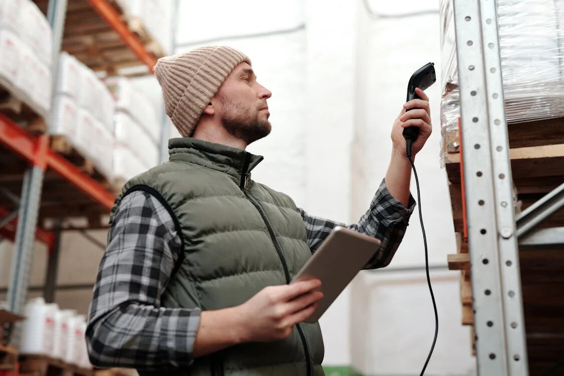 Warehouse worker scanning inventory with a handheld barcode reader