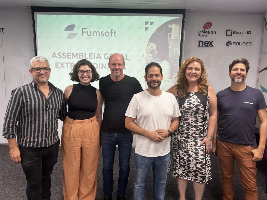 Six participants at Fumsoft’s March 2024 assembly, standing before a projection screen