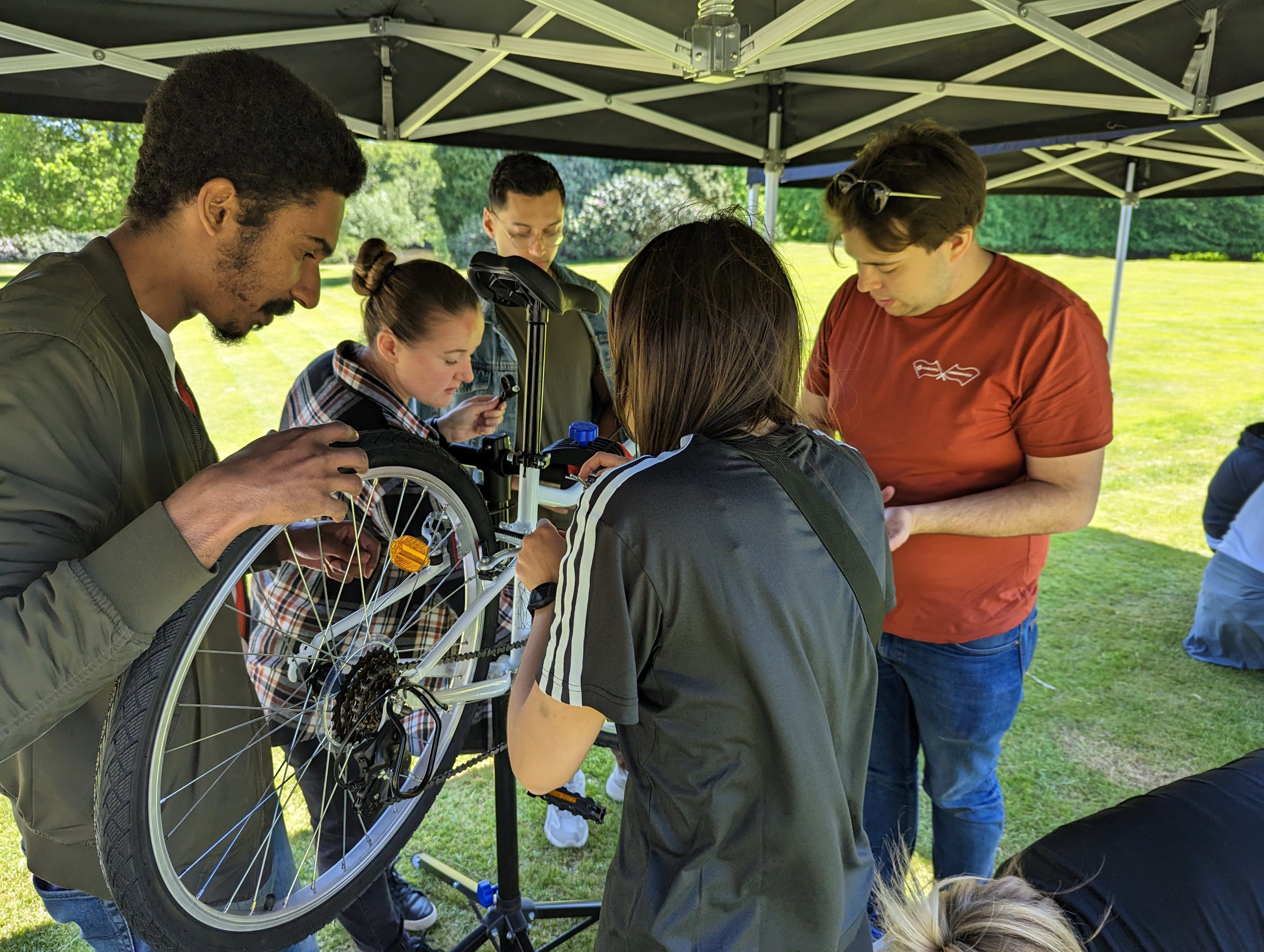 FundApps colleagues working together to assemble a bicycle outdoors