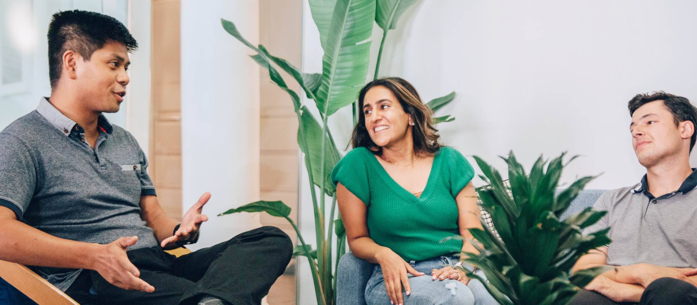 Three Fundbox team members talking together in a plant-filled office