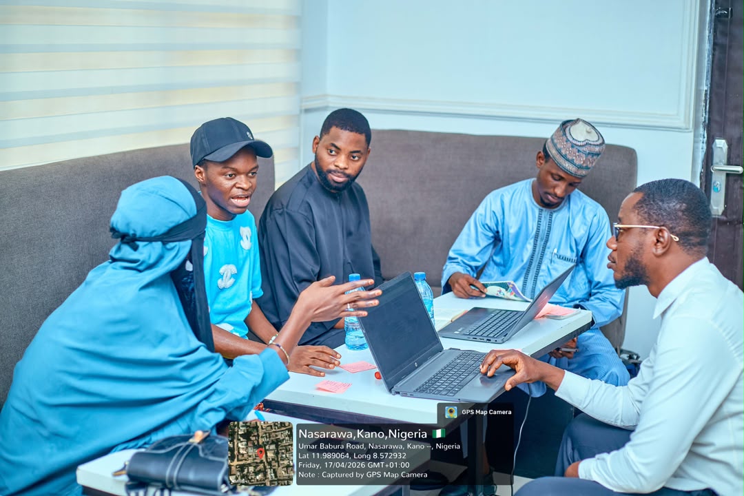 Five participants discussing work around laptops at a FutureMap session in Kano