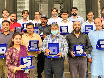 FutureNow staff holding long-service awards in the company's September 2020 photograph