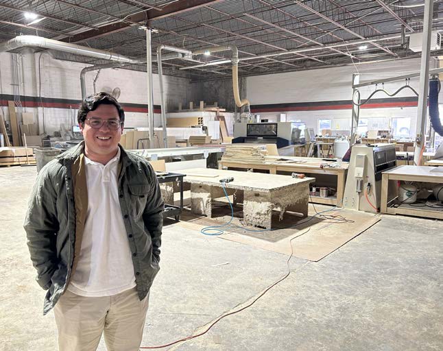 A person standing inside BILTCO’s millwork workshop, surrounded by machinery and materials