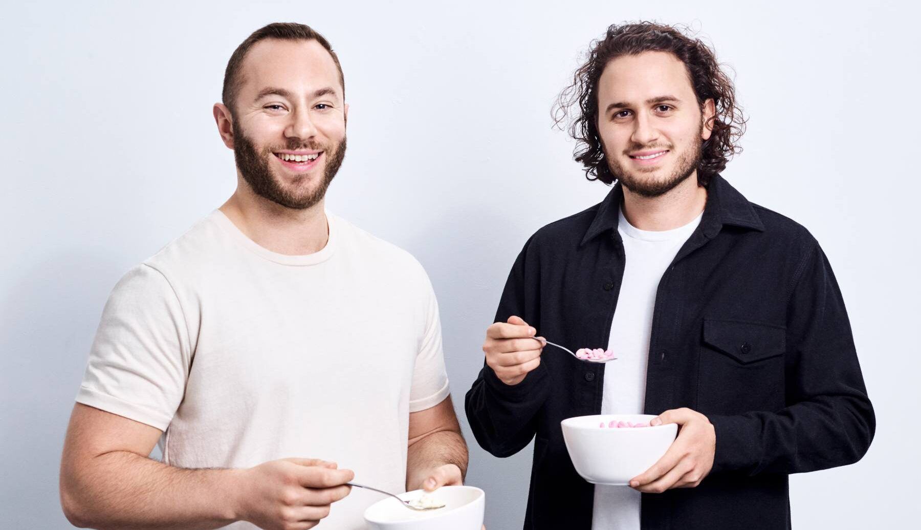 Gabi Lewis, left, and Greg Sewitz holding bowls of cereal and spoons