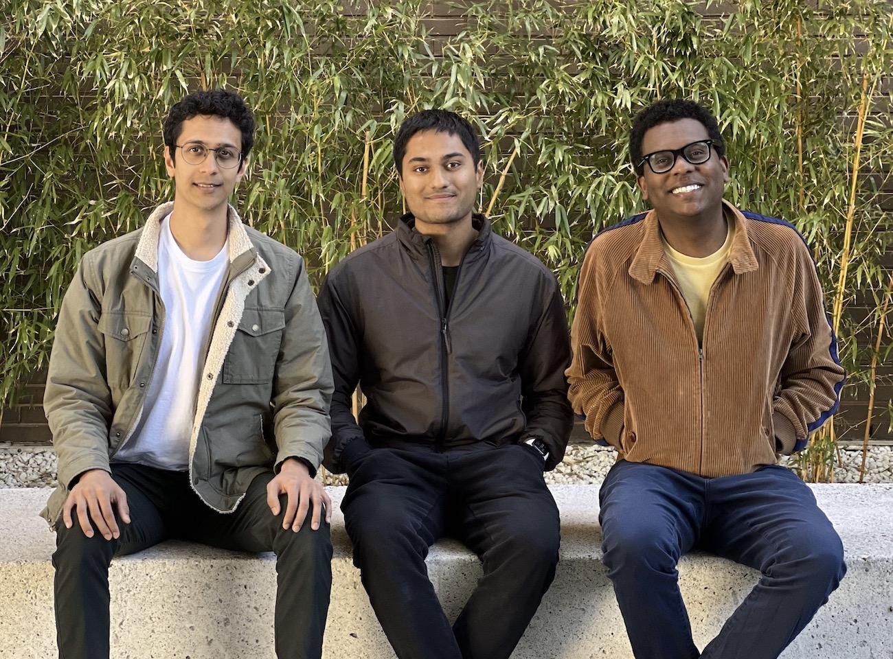 Openlayer’s three co-founders sitting together outdoors, with Gabriel Bayomi at right.