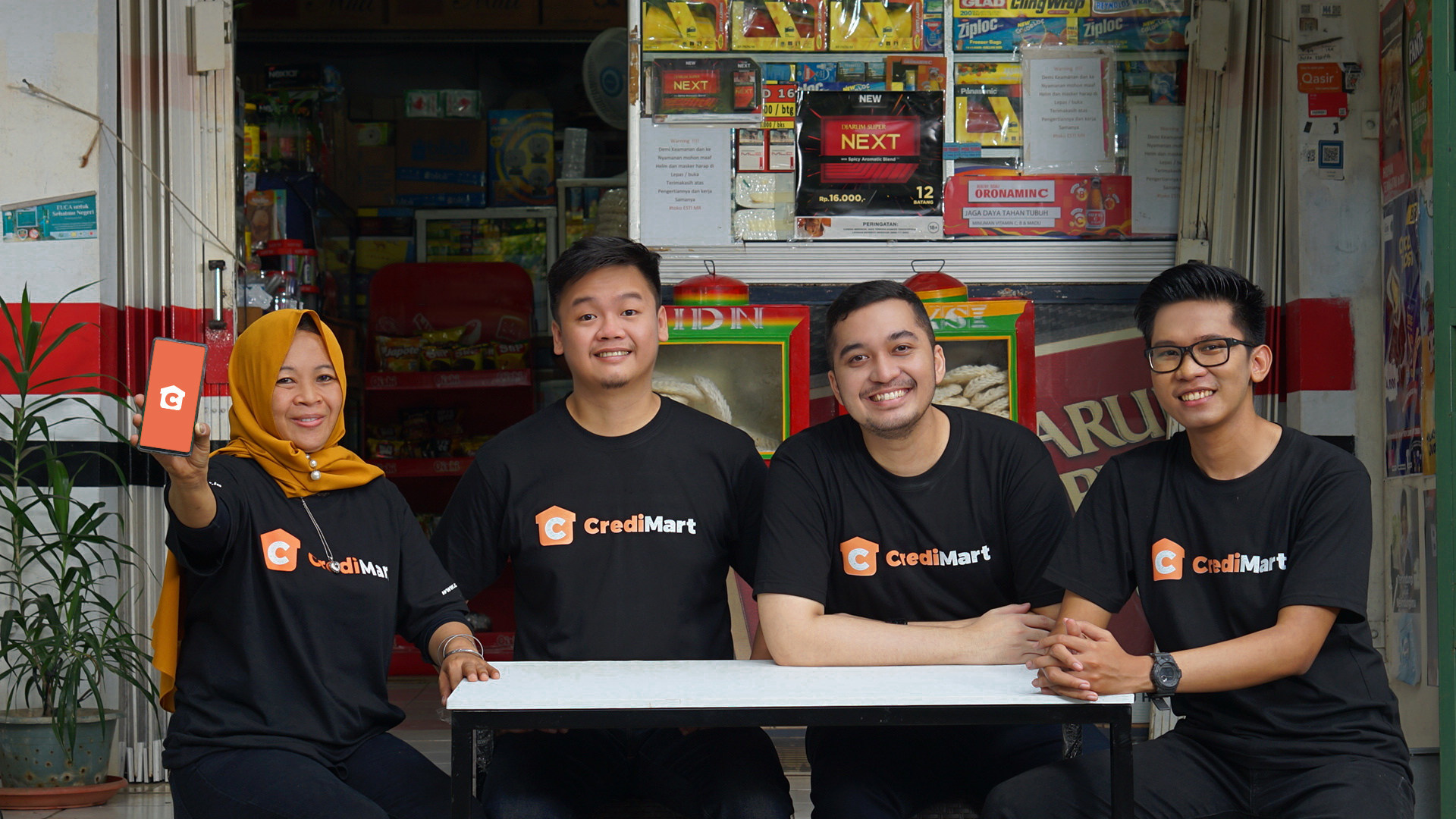 A CrediMart retail customer with CrediBook’s three founders outside a neighborhood shop