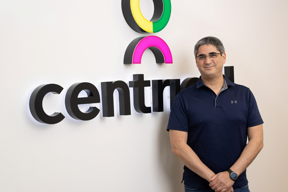 Gal Rimon standing beside the Centrical name and colorful company symbol in an office